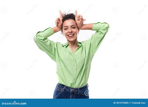 Una Joven Modelo Femenina Delgada Y Rizada De Brunette Vestida Con Una Camisa Verde Claro Hace