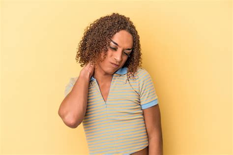 Jovem transexual latina isolada em fundo amarelo dor no pescoço devido ao estresse