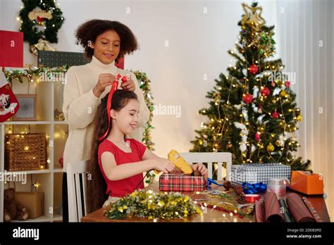 Girl Tying Hair Of Friend Stock Photo Alamy