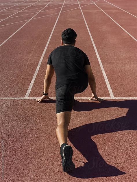 Man In Crouch Start Pose On Race Track By Stocksy Contributor Milles