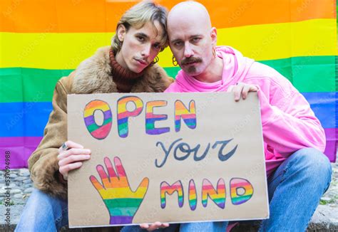 Homosexual Gay Couple Showing His Banner At Lgbt Pride Parade Outdoor With Rainbow Flag