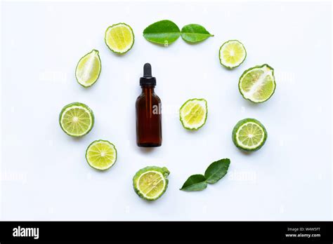 Bottle Of Essential Oil And Fresh Kaffir Lime Or Bergamot Fruit With Leaves Isolated On White