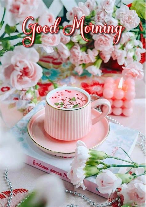 A Pink Coffee Cup And Saucer Sitting On Top Of A Table Next To Flowers