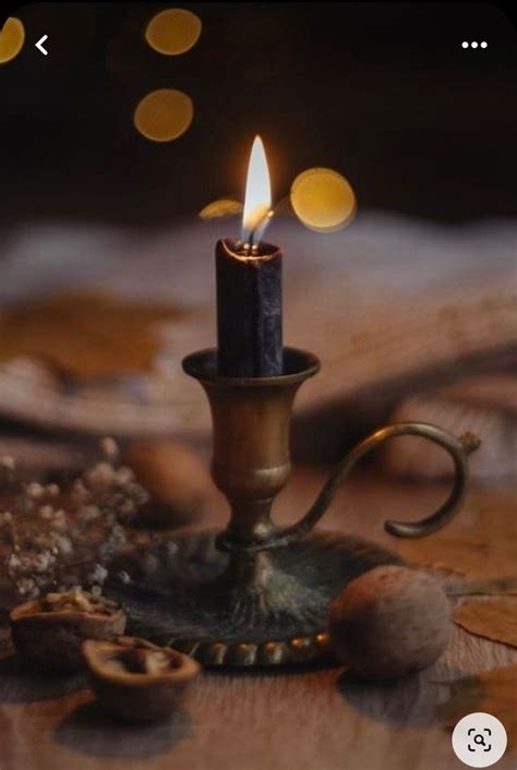 A Lit Candle Sitting On Top Of A Wooden Table