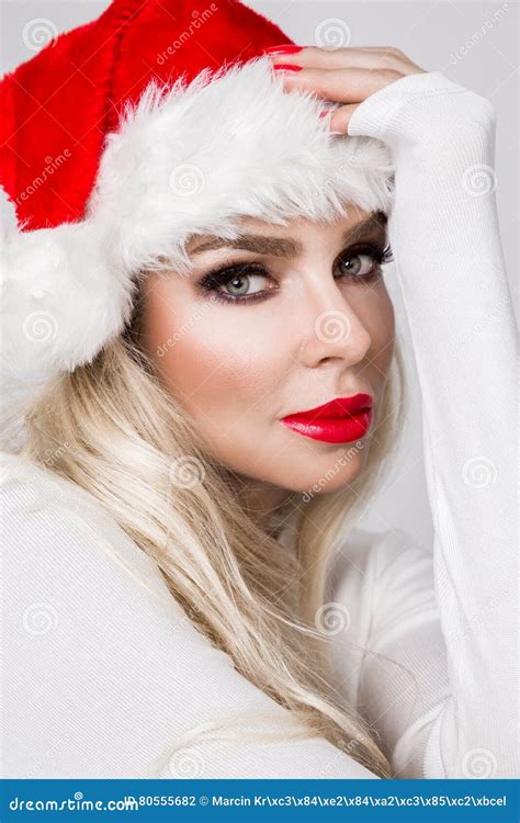 Beautiful Blonde Female Model Dressed As Santa Claus In A Red Cap Stock