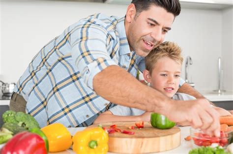 Padre Guapo Mostrando A Su Hijo C Mo Preparar Verduras Foto Premium