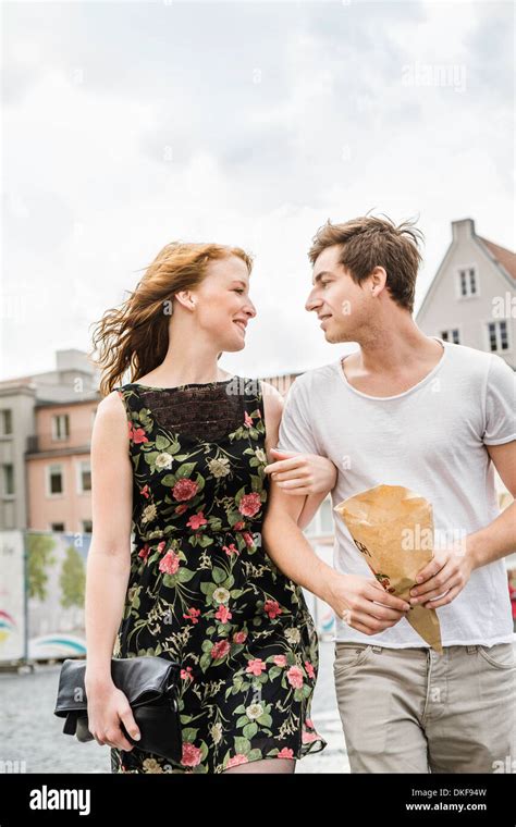 Young Couple Walking Through Town Arm In Arm Stock Photo Alamy