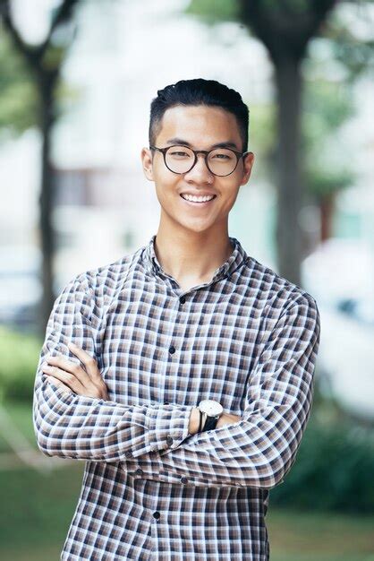 Premium Photo Portrait Of Happy Smiling Young Man In Glasses And Plaid Shirt Crossing Arms And