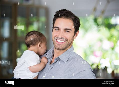 Portrait Of Cheerful Father Carrying Baby Stock Photo Alamy