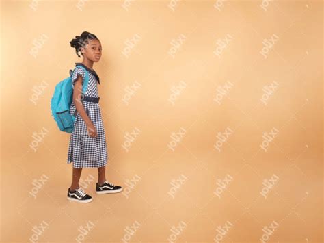 Une écolière africaine en uniforme scolaire avec son sac à dos allant à