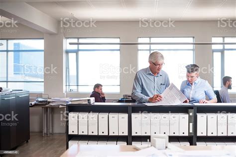 Business People Reading Documents At Counter Stock Photo Download