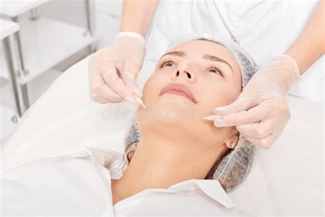 Beautician Applies Facial Oil Capsules On Woman Face For Rejuvenation