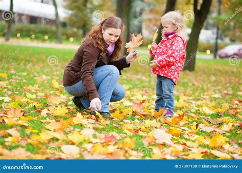 Mother And Daughter Gathering Leaves In Park Stock Photo Image Of