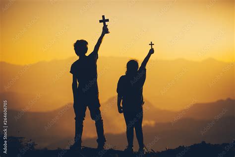 Two people standing holding christian cross for worshipping God at ...