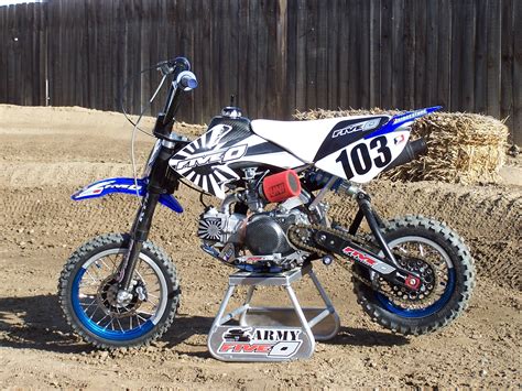 A Dirt Bike Sitting On Top Of A Metal Stand In The Middle Of A Dirt Field