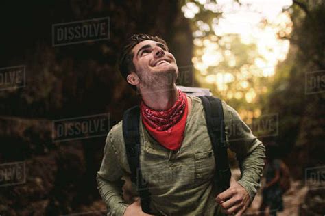 Caucasian Man Walking Through A Mountain Trail With Friends At The Back