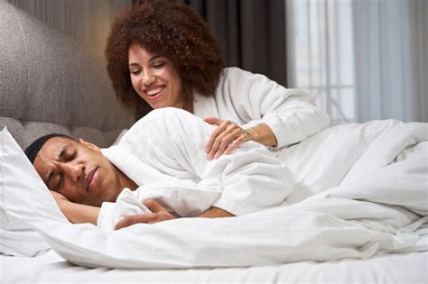 Traveling Multiracial Couple Resting In Comfortable Bed In Hotel Room