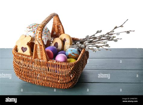 Gift Basket With Painted Easter Eggs Pussy Willow Branches Cookies And Cake On Table Against