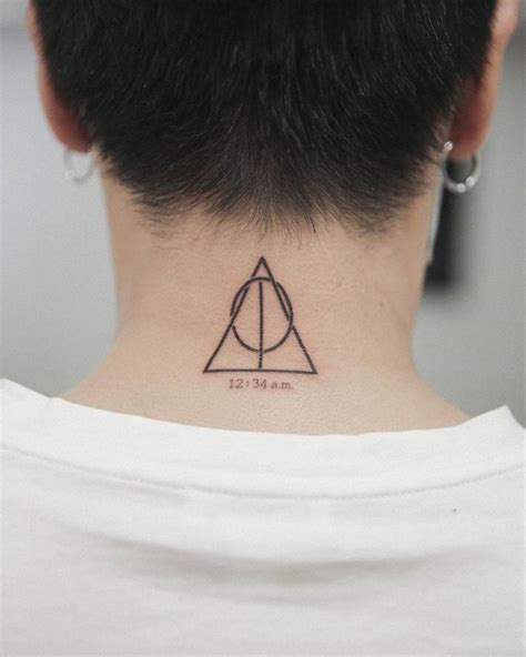 Deathly Hallows symbol + 12:34 am tattoo on the back of