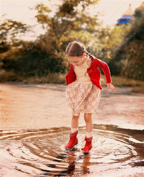 Kid Jumping Into A Puddle — Stock Photo © Kolinkotanya 49620911