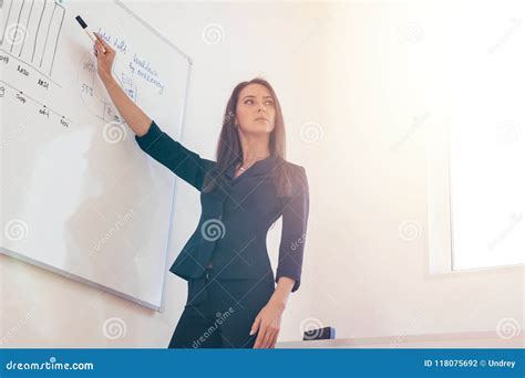 Female Professional Tutor Explaining Diagram Drawn On White Board Stock