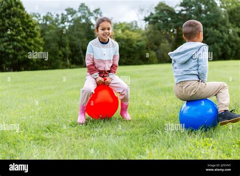 Happy Children Bouncing On Hopper Balls At Park Stock Photo Alamy