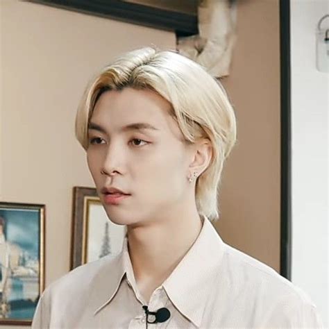 A Man With Blonde Hair Wearing A White Shirt