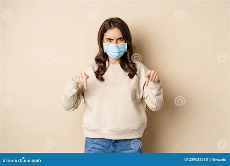 Angry Woman In Medical Face Mask Pointing Fingers Down And Looking