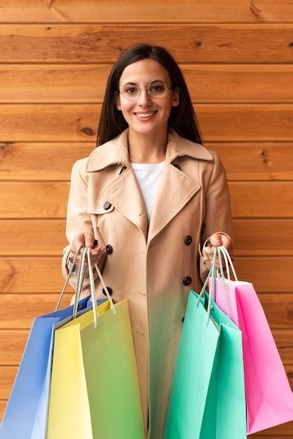 Mulher feliz óculos segurando sacolas de compras Foto Grátis