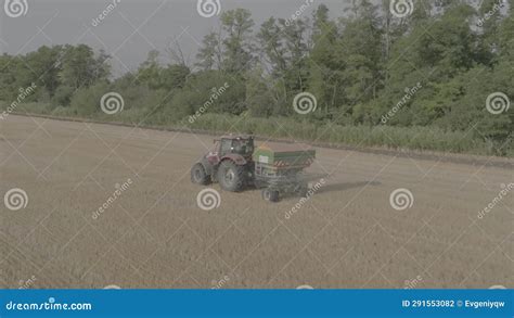 Farmer On Tractor Fertilizing Agricultural Field Spreading Mineral