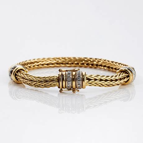 ARMBAND 18 k guld virkad länk mellandelar med dekor av 27