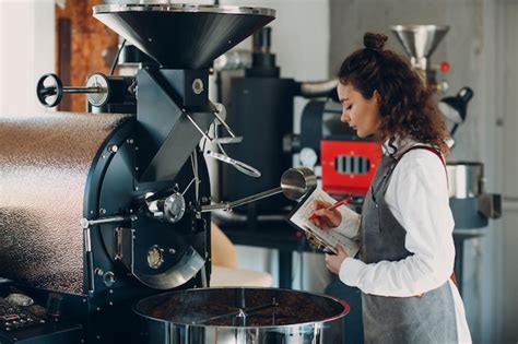 Máquina tostadora de café y mujer barista con lápiz de escritura de