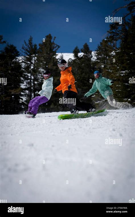 Snowboard instructor riding and giving a snowboard lesson at a ski ...