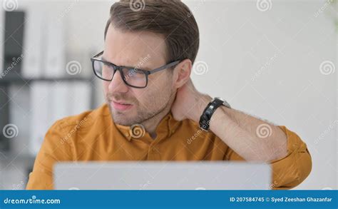 Close Up Of Young Man With Laptop Having Neck Pain In Office Stock