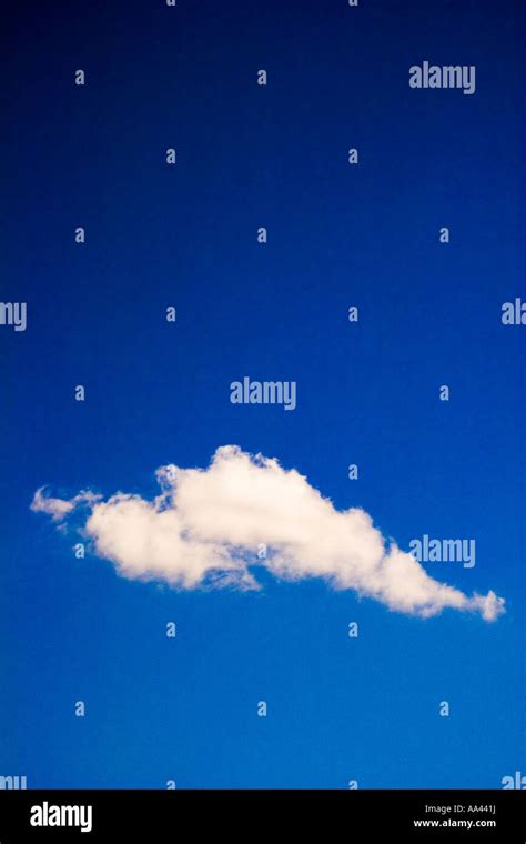 A Single White Cloud Against Dark Blue Sky Stock Photo Alamy