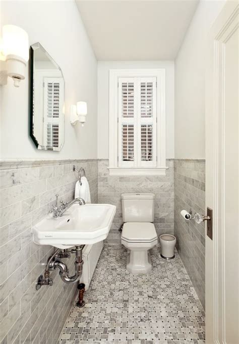 A White Toilet Sitting Next To A Sink In A Bathroom Under A Window With