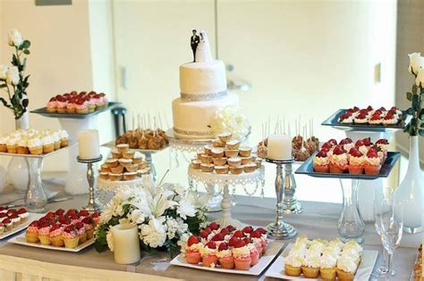 a simple and elegant dessert table styled with a white tablecloth, with ...