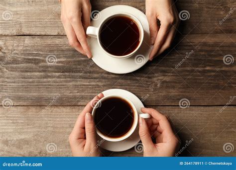 Women With Cups Of Aromatic Coffee At Wooden Table Top View Stock