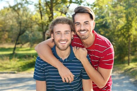 Retrato De Feliz Pareja Gay Sonriente En El Parque Foto Premium