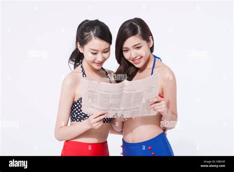 Two Women In Retro Style Bikini Holding Newspaper And Looking At It Together Stock Photo Alamy