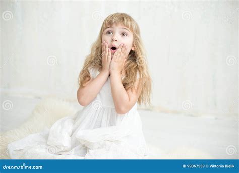 Portrait Of Pretty Little Girl In White Dress She Is Surprised And