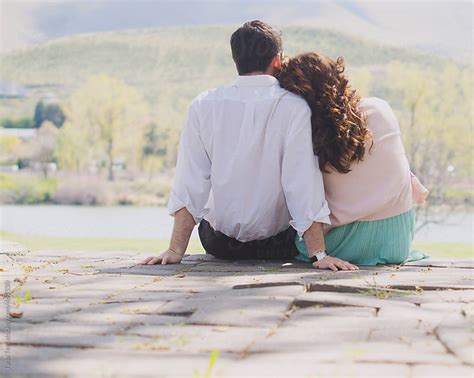 Young Couple Sit Together On A Step Looking Out At River By Tana Teel