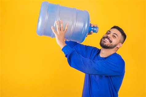 Premium Photo Young Boy With Big Gallon Of Water Drinking On Yellow