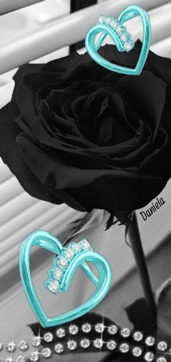 A Black Rose With Diamonds In The Shape Of A Heart Is Sitting On Top Of