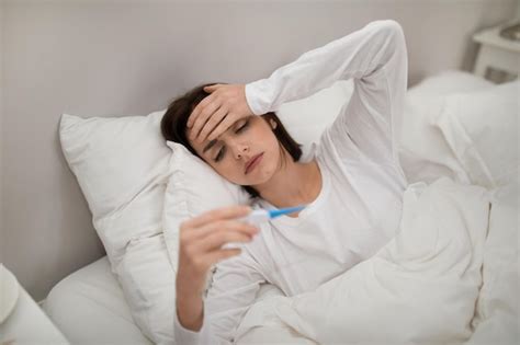 Mujer Enferma Con Fiebre Comprobando Su Temperatura En La Cama Foto