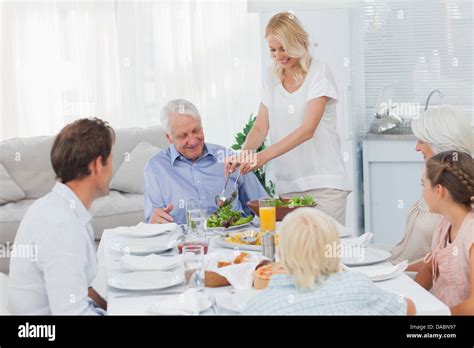 Woman Serving Salad At The Dinner Table Stock Photo Alamy