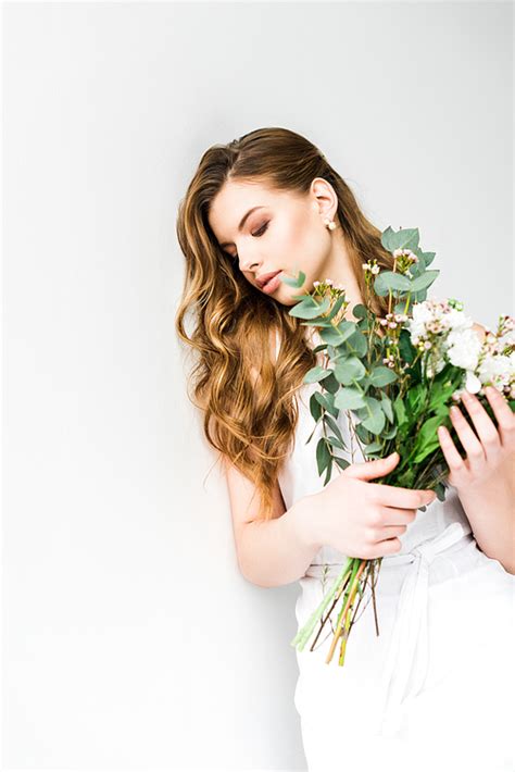 유토이미지 Attractive Young Woman Holding Bouquet Of Flowers On White