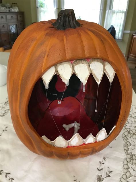 A Carved Pumpkin With Its Mouth Open On A Table