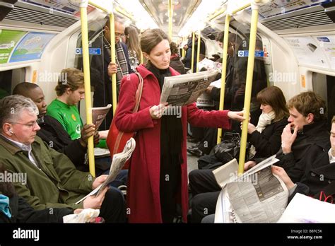 People reading newspapers on the London Underground Stock Photo - Alamy