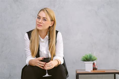 Beautiful Blonde Woman Enjoying Glass Of Red Wine And Looking At Camera